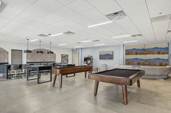 a game room with two pool tables and a bar